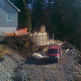 Arbeid med vei og vegg utenfor hus