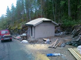 Pumpehus ved vei i skog
