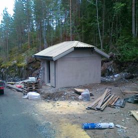 Pumpehus ved vei i skog